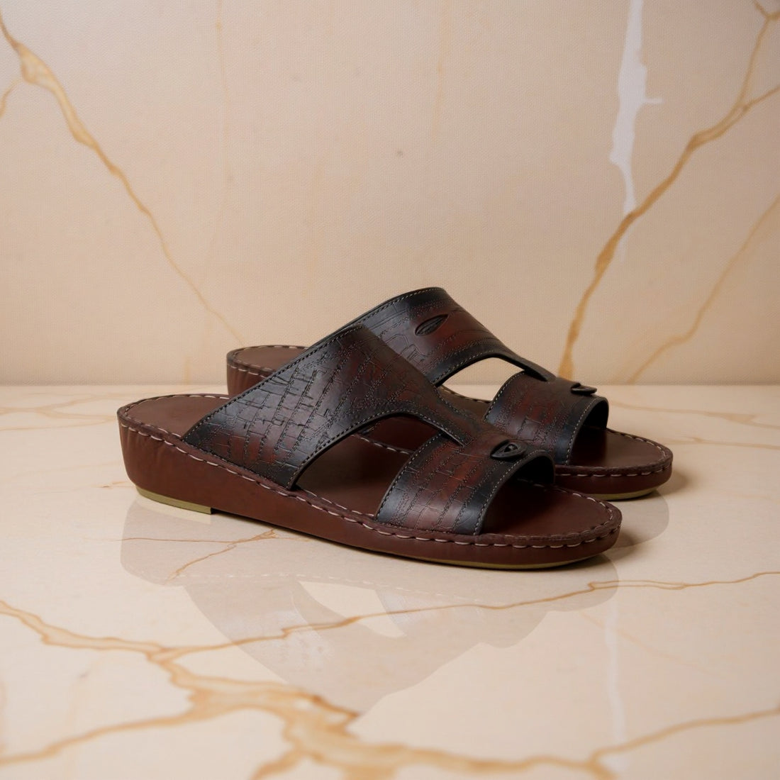 Brown patterned Arabic sandals on marble