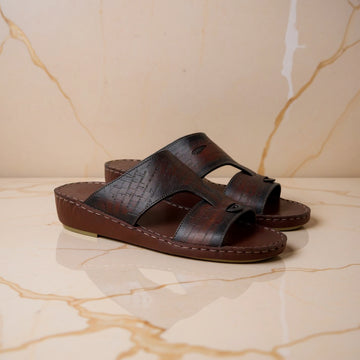 Brown patterned Arabic sandals on marble
