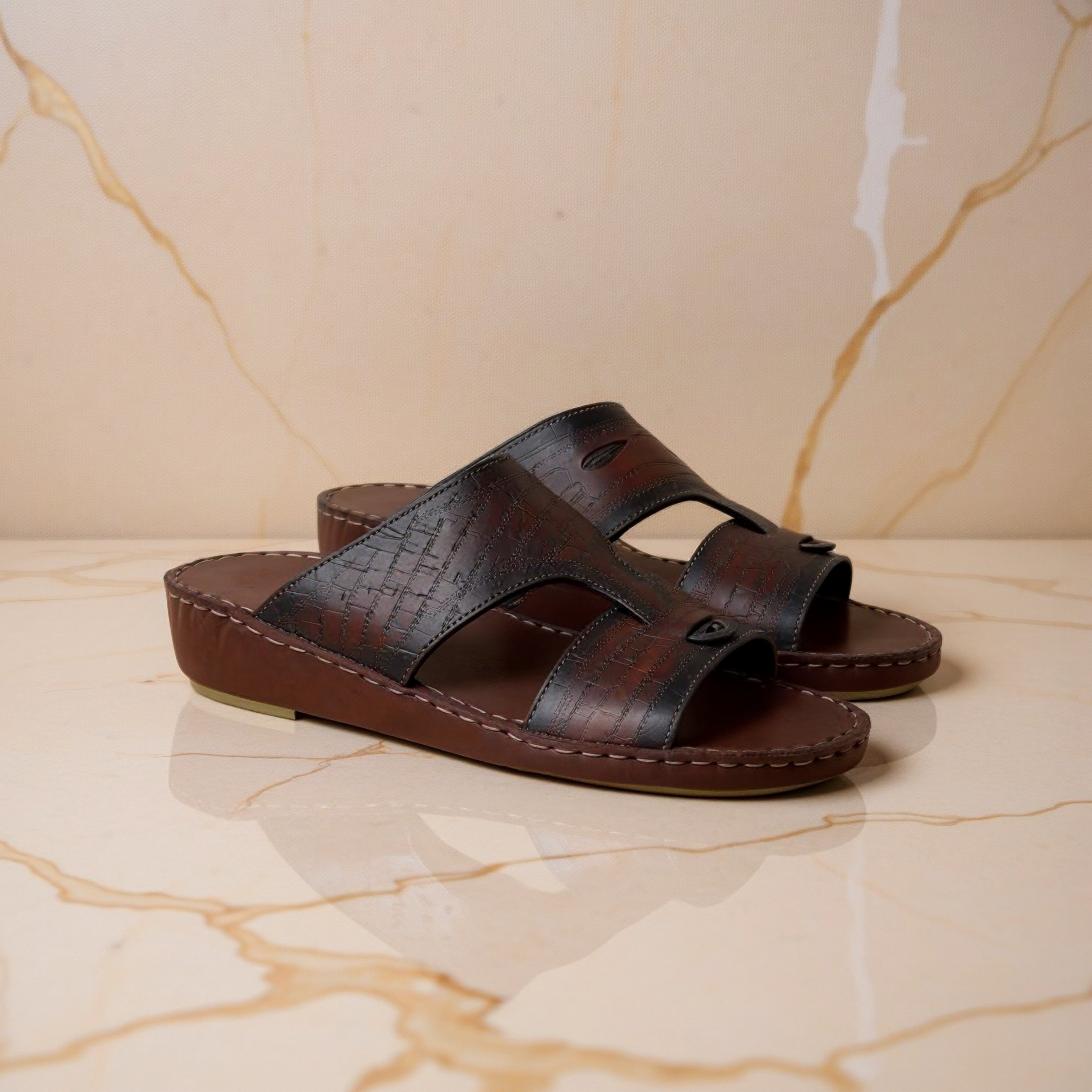 Brown patterned Arabic sandals on marble